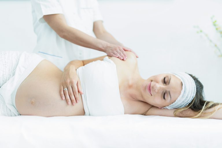 Pregnant woman receiving a body massage.