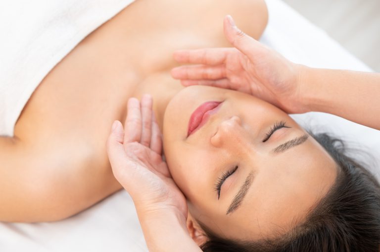 Face massage. Close up of young woman getting spa massage treatment at spa salon.