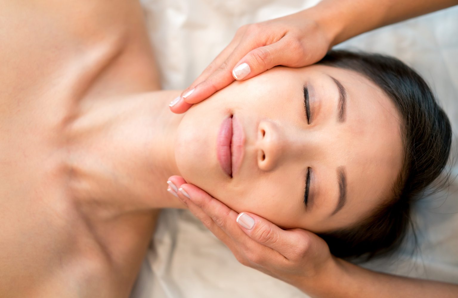 Asian woman getting a face massage at the spa